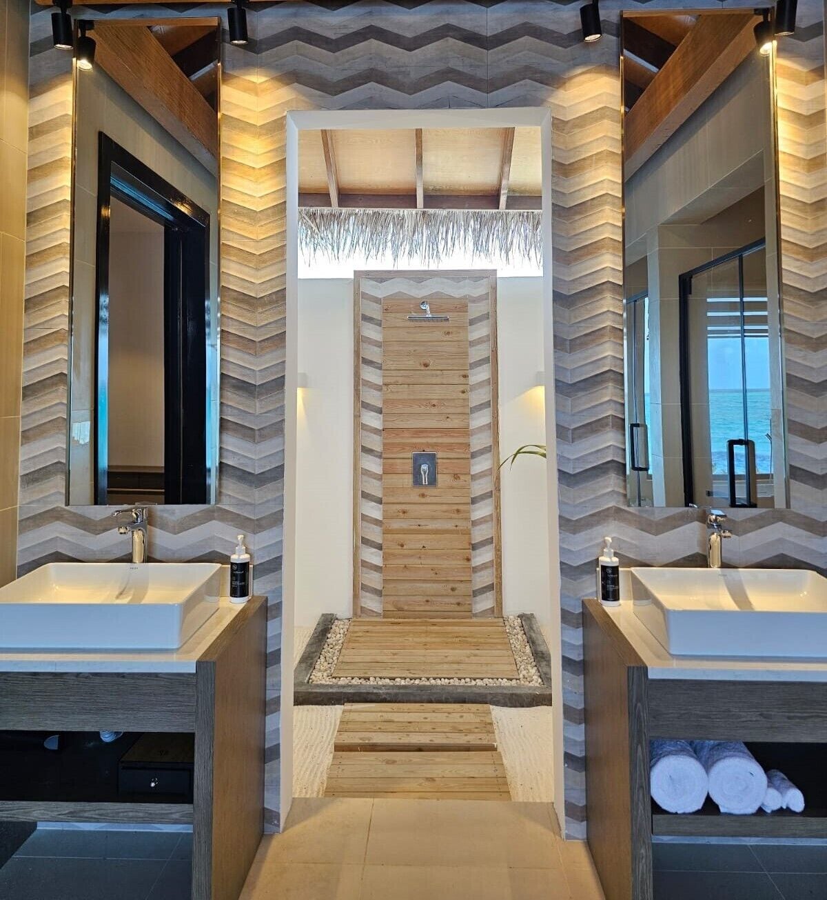 Un baño moderno con dos lavamanos, un mueble de tocador de madera y un espejo.