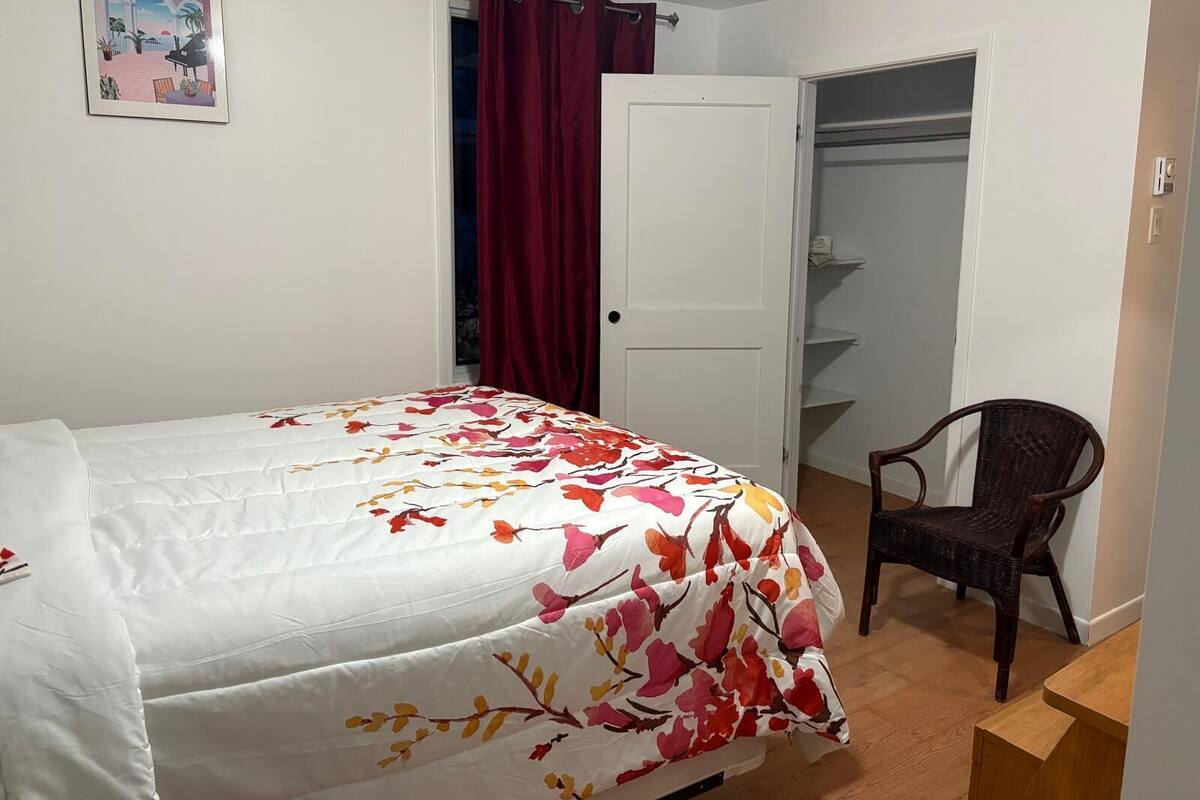 Une chambre à coucher avec un lit, une chaise, une armoire et une porte.
