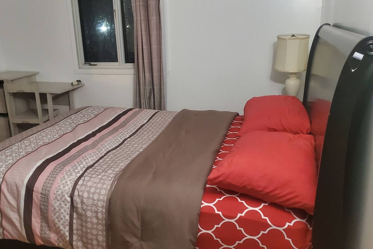 Une chambre à coucher avec un lit, un bureau et une fenêtre.