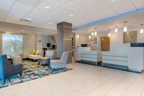 A hotel lobby with a reception desk, seating area, and a large window with a view. - Comfort Inn & Suites Melbourne Viera (Melbourne)