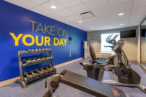 A gym with exercise equipment, a wall with motivational text, and a clock. - Comfort Inn & Suites Melbourne Viera (Melbourne)
