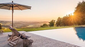 Relax by the pool surrounded by lush landscape and rolling hills.