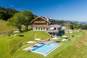 Enjoy the surrounding landscape from the spacious balcony area, overlooking a well-maintained lawn with a swimming pool.