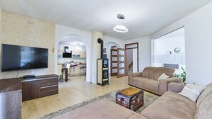 Un soggiorno moderno con una televisione a schermo piatto, un mobile TV in legno, un divano beige e un tavolino da caffè.