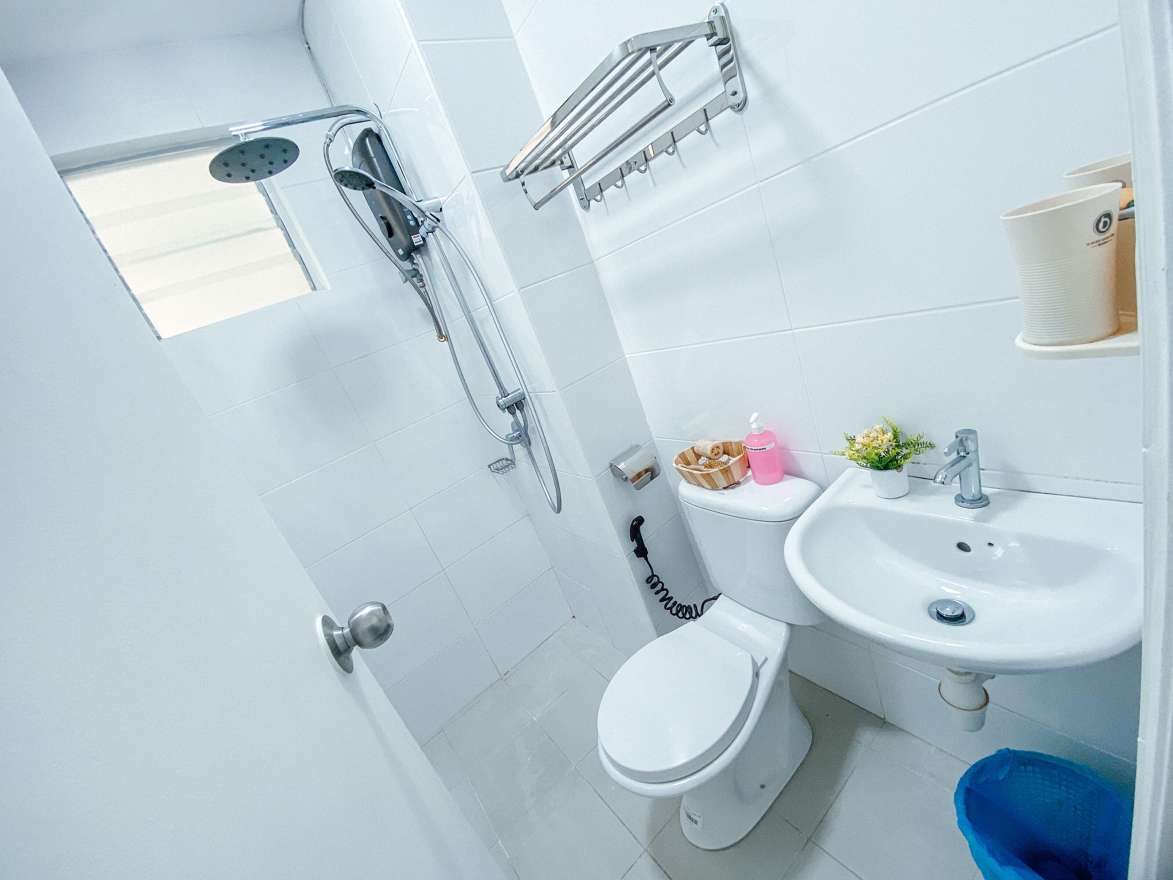 A bathroom with a toilet, sink, and shower.
