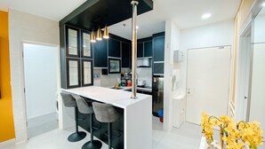 Een moderne keuken met een centraal eiland, barkrukken en hanglampen.