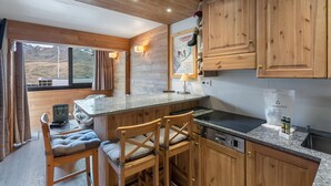 Eine Küche mit Holzausstattung, einer Arbeitsplatte aus Granit und Blick auf eine Berglandschaft.