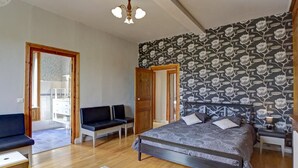 A bedroom with a bed, a desk, a chair, a sofa, and a wooden floor. - Spacious lodging with pool and pets allowed for 15 guests (Mornand-en-Forez)