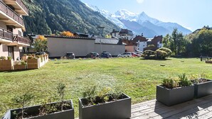 A hotel with a mountain view, a parking area, and a deck with planters.