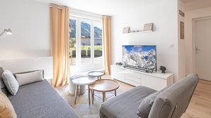 A modern living room with a sofa, a coffee table, and a TV.