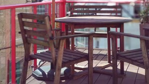 A wooden deck with a table and chairs, overlooking a body of water with buildings in the background. - Casa Boutique en Puerto Pesquero de Asturias (Viavélez)
