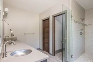 Une salle de bain moderne avec un lavabo, un miroir et une douche en verre.