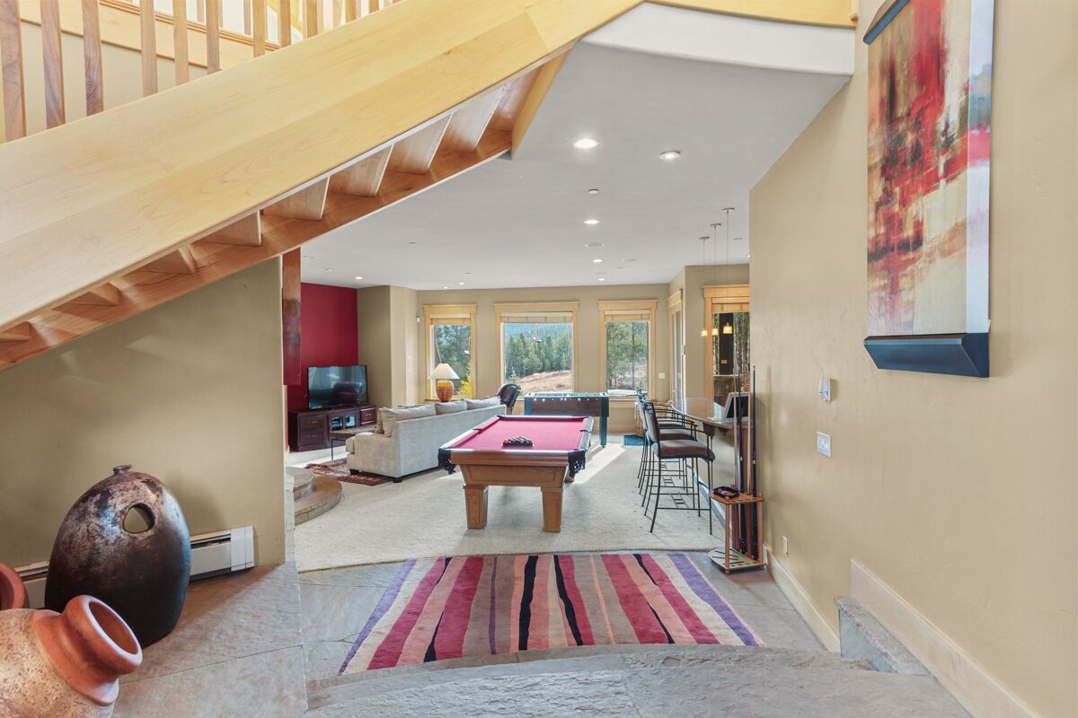A spacious living area with a pool table, a sofa, and a television.