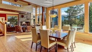 A spacious dining area with a large wooden table and chairs, a fireplace, and large windows offering a view of the outdoors. - Ski-In/Ski-Out House | Hot Tub | Views (Copper Mountain)