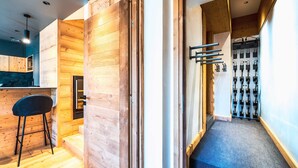 Een modern interieur met een houten wand, een bar en een trap naar een kamer met uitzicht.