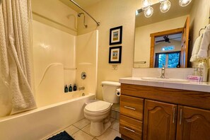 A bathroom with a bathtub, toilet, and vanity with wooden cabinets. - Beautiful townhome on Ski Hill Road, 1 mile from Driggs + 11 miles from Grand Targhee (Driggs)