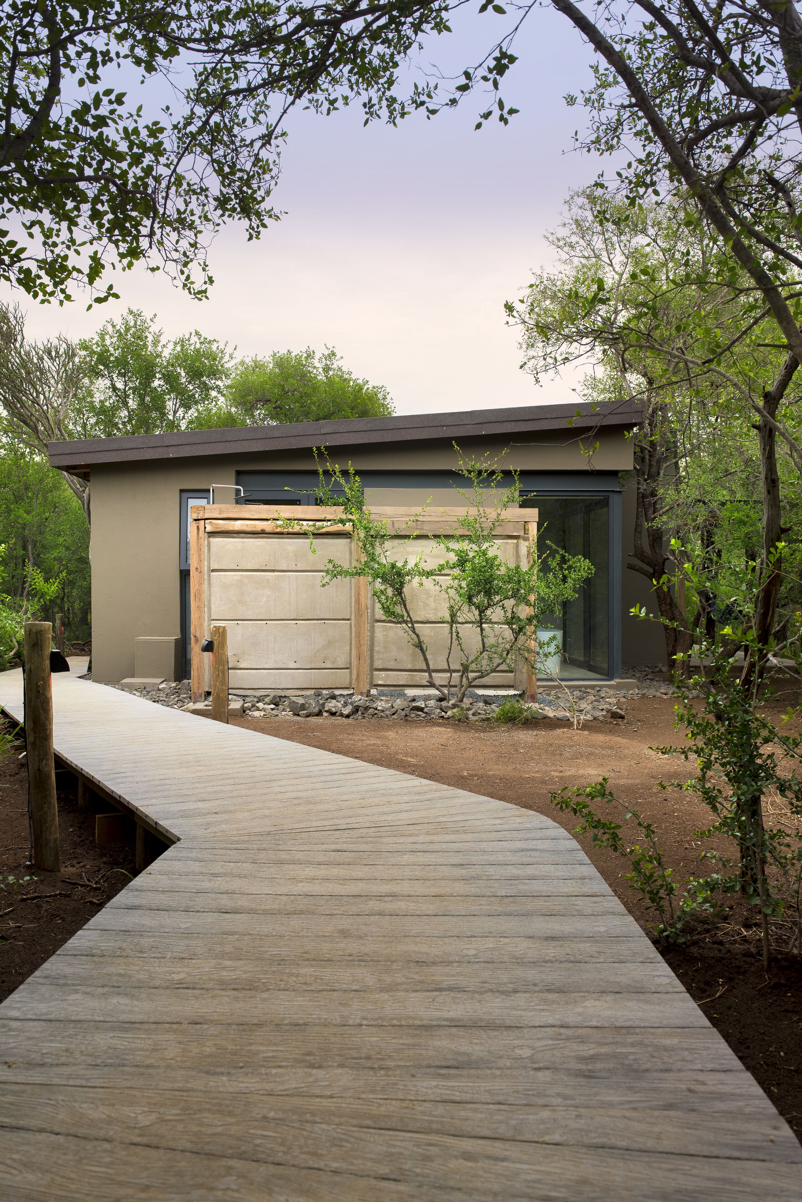 A modern building with a wooden deck leading to a garage.
