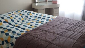 A bedroom with a bed, a dresser, a mirror, and two heart-shaped decorations on the wall. - 2 Pièces 50m² Ensoleillés + 2 Terrasses BBC (Menton)