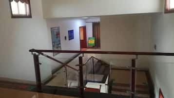 A staircase with a glass railing, leading to an upper floor.