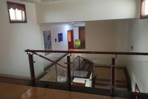 A staircase with a glass railing, leading to an upper floor. - Cuilinyuan Hotel (Zibo)