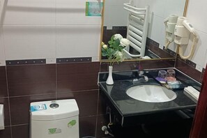 A bathroom with a white toilet, a black sink, a mirror, and a towel rack. - Cuilinyuan Hotel (Zibo)