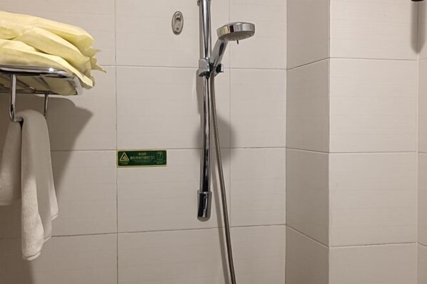A shower area with a chrome showerhead and a towel rack with a yellow towel. - Cuilinyuan Hotel (Zibo)