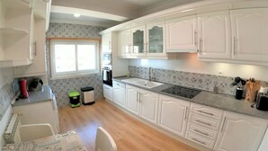 A compact kitchen with white cabinets, a sink, and a window. - Carnaxide, modern T1 apartment w/ balcony, Lisbon (Carnaxide)