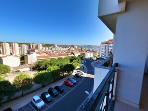 Un parking rempli de voitures, un ciel dégagé et des bùtiments en arriÚre-plan.