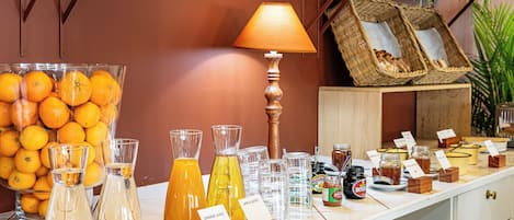 A breakfast buffet with various juices and jams.