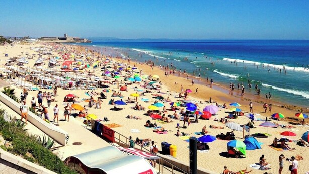 A crowded beach with numerous umbrellas and people. - Carcavelos, Cozy 3 bedroom apartment in Cascais (Carcavelos)