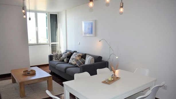 A modern living room with a sofa, a dining table, and chairs. - Madeira, 3 bedroom apartment w Ocean Views Funchal (Funchal)