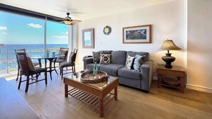 Ein Wohnzimmer mit Sofa, Sesseln, Couchtisch, Lampe und Meerblick.