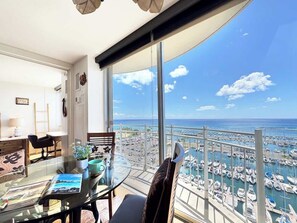 Un balcón con vista a un puerto deportivo y al océano.