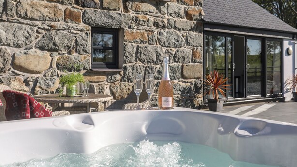 A stone building with a hot tub in front. - Hen Felin (Pwllheli)