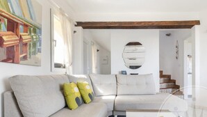 Ein modernes Wohnzimmer mit einem Ecksofa, einem Couchtisch und einem Gemälde an der Wand.