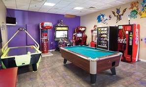 Enjoy games and entertainment in this indoor recreational area featuring a pool table and arcade games.
