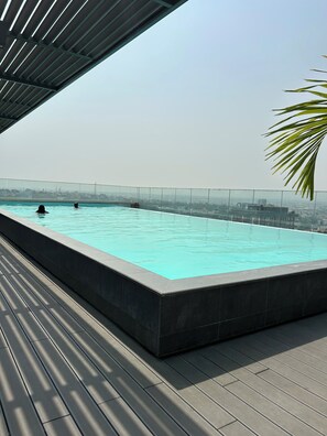 A rooftop infinity pool with a clear view of the cityscape.