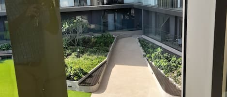 A multi-story residential building with balconies, a central courtyard, and a pathway.