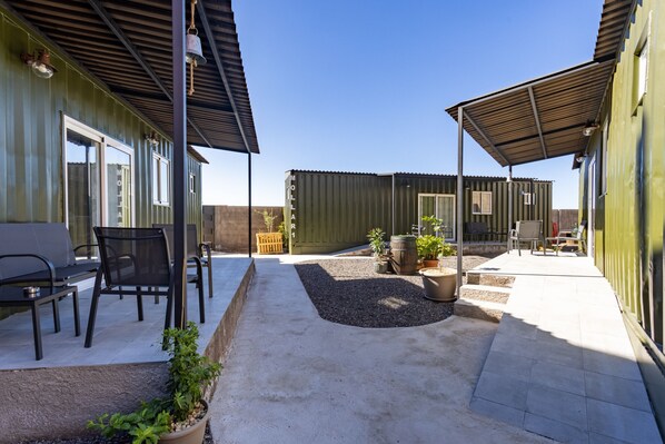 A patio area with outdoor seating, a covered section, and a green container building labeled "MOLLA".