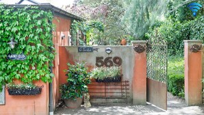Una entrada protegida por un portón con un letrero que dice 'Le Jardin' y el número '569'.