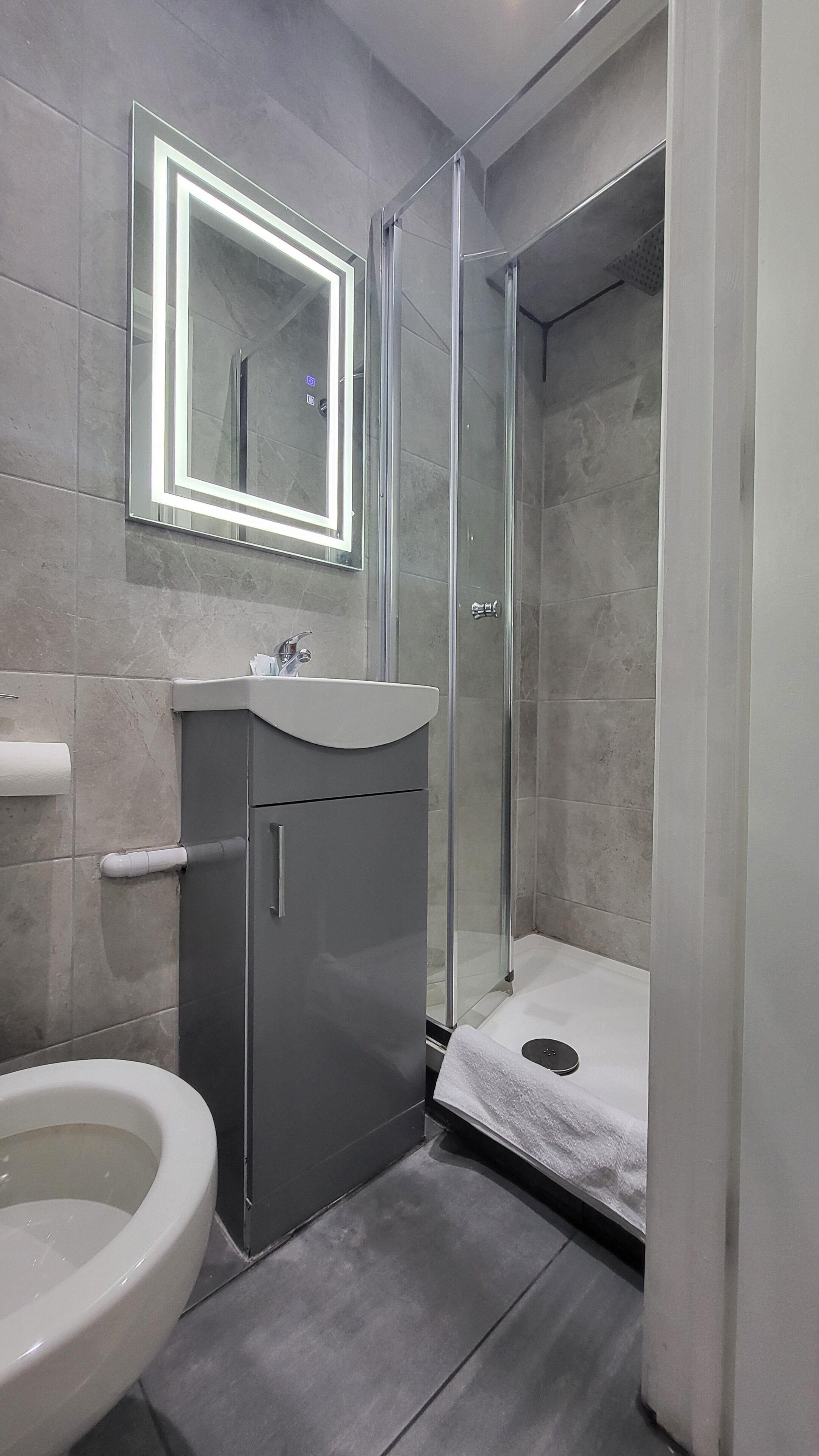A bathroom with a toilet, sink, and shower.