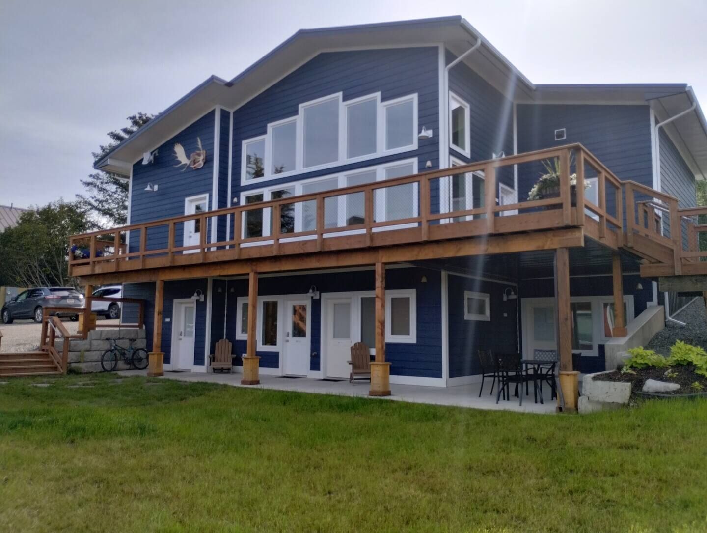 A two-story house with a wooden deck and a covered outdoor area.
