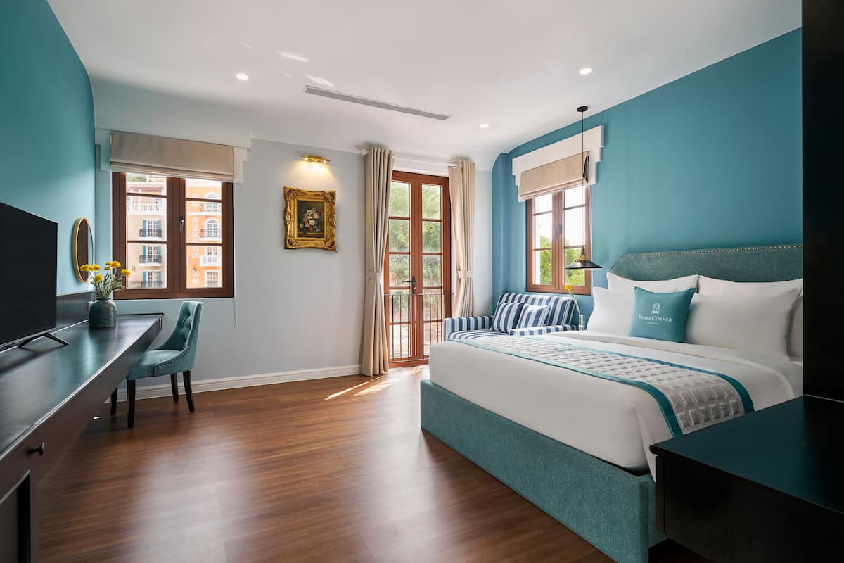A modern bedroom with a large bed, a desk, and a chair.