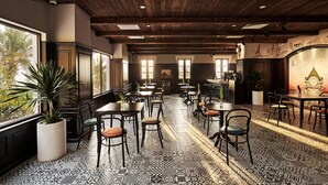 A restaurant with a high ceiling, patterned floor, and multiple tables and chairs. - Times Corner Sorrento Boutique Hotel (Phu Quoc)