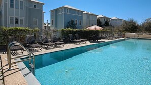 A swimming pool with lounge chairs and umbrellas, surrounded by buildings. - 30A Retreat-Beach Access Nearby-Comm Pools-4 Bikes (Santa Rosa Beach)