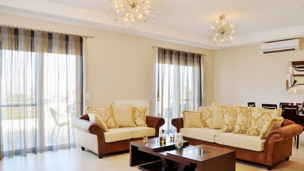 A spacious living room with two sofas, a coffee table, and a chandelier. - ELIA KOUNOUPIDIANA (Chania)