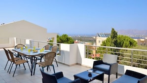 A rooftop terrace with a dining table and chairs, a small table with a bowl, and a view of the city and mountains. - ELIA KOUNOUPIDIANA (Chania)