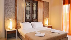 A hotel room with a large bed, two bedside tables, a wooden headboard, and a chandelier. - ELIA KOUNOUPIDIANA (Chania)