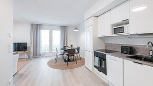 A modern kitchen with white cabinets, a microwave, a toaster, and a dishwasher.