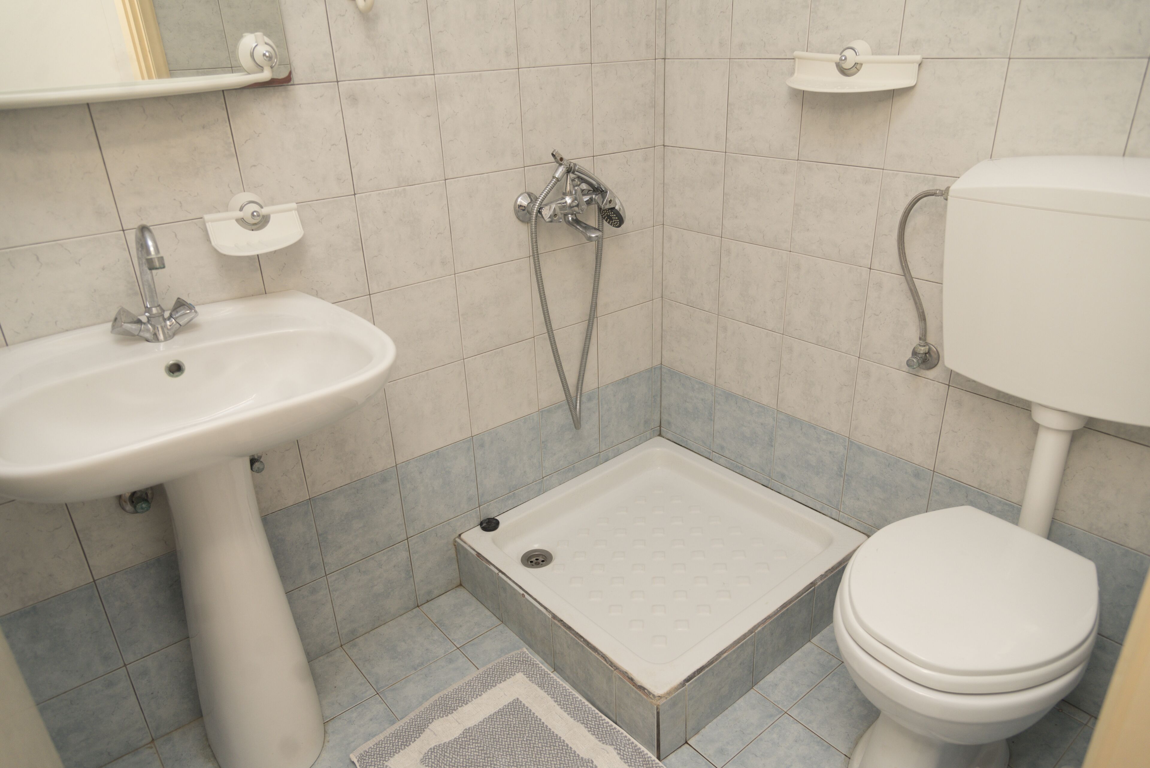 A bathroom with a sink, shower, and toilet.